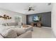 Cozy living room with a large sectional sofa, a dark accent wall with a TV, and a stylish ceiling fan at 739 Peg Ct, St Cloud, FL 34772