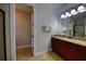 Well-lit bathroom with a vanity, granite countertop, and a walk-in shower at 7664 Wilmington Loop, Kissimmee, FL 34747