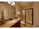 A well-lit bathroom featuring a granite countertop, wood cabinets, and a glass-enclosed shower at 7664 Wilmington Loop, Kissimmee, FL 34747