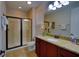 Bathroom featuring granite countertops, framed mirror and a glass enclosed shower in a modern well lit space at 7664 Wilmington Loop, Kissimmee, FL 34747