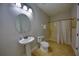 Bathroom featuring a white pedestal sink, toilet, and shower with patterned curtain at 7664 Wilmington Loop, Kissimmee, FL 34747