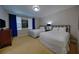 A carpeted bedroom with two beds and blue curtains at 7664 Wilmington Loop, Kissimmee, FL 34747