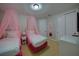 bedroom showcasing two twin beds with sheer pink canopies, and white matching furniture and decor at 7664 Wilmington Loop, Kissimmee, FL 34747