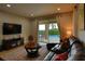Cozy living room with a large sofa, patterned rug, and sliding glass doors leading to the pool at 7664 Wilmington Loop, Kissimmee, FL 34747