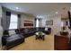 Inviting living room featuring a leather sectional sofa, artwork, and a round coffee table at 7664 Wilmington Loop, Kissimmee, FL 34747
