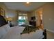 Comfortable main bedroom with a dark wood bed frame, TV, and view of the backyard pool area at 7664 Wilmington Loop, Kissimmee, FL 34747