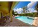 Inviting pool area with a hot tub, palm trees, and patio furniture, perfect for relaxation at 7664 Wilmington Loop, Kissimmee, FL 34747