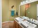 Bathroom featuring a double sink vanity, vanity mirror, and a shower in background at 7733 Beridale Ct, Orlando, FL 32818