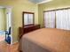 Bright bedroom featuring hardwood floors, a large dresser, and neutral-toned curtains at 7733 Beridale Ct, Orlando, FL 32818