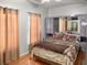 Well-lit bedroom featuring hardwood floors and neutral-toned curtains for a warm ambiance at 7733 Beridale Ct, Orlando, FL 32818