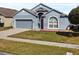 Charming single-Gathering home with gray exterior, two-car garage, and red front door at 7733 Beridale Ct, Orlando, FL 32818