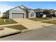 View of single-Gathering home with attached garage, driveway, lawn, and mailbox at 7733 Beridale Ct, Orlando, FL 32818