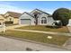 Charming single-Gathering home with a well-maintained lawn, red front door, and a two-car garage at 7733 Beridale Ct, Orlando, FL 32818
