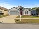 Charming single-Gathering home with a well-maintained lawn, red front door, and a two-car garage at 7733 Beridale Ct, Orlando, FL 32818