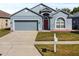 Charming single-Gathering home featuring a gray exterior, two-car garage, and a red front door at 7733 Beridale Ct, Orlando, FL 32818