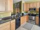 Kitchen with granite countertops, stainless steel appliances, and natural wood cabinetry at 7733 Beridale Ct, Orlando, FL 32818