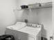 Laundry area with standard washer and dryer, as well as wire shelving at 7733 Beridale Ct, Orlando, FL 32818