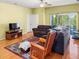 Cozy living room with wood flooring, ceiling fan, and comfortable sofas and chairs at 7733 Beridale Ct, Orlando, FL 32818