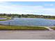 Scenic view of a calm pond reflecting the sky, surrounded by lush green grass and trees at 7733 Beridale Ct, Orlando, FL 32818