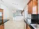 View of kitchen into living area showing granite counter, stainless appliances, and breakfast bar at 786 Seneca Meadows Rd, Winter Springs, FL 32708