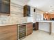 Stylish kitchen with marble accent wall and wine cooler perfect for entertaining at 786 Seneca Meadows Rd, Winter Springs, FL 32708