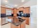 Bright kitchen with dark granite countertops and wood cabinets featuring a center island at 786 Seneca Meadows Rd, Winter Springs, FL 32708