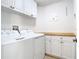 Well-lit laundry room with modern washer, dryer and built in shelving at 786 Seneca Meadows Rd, Winter Springs, FL 32708
