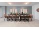 Elegant dining area featuring a long table set for a meal and stylish wall decor at 8879 Qin Loop, Kissimmee, FL 34747