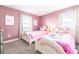 A pink themed bedroom with white twin beds and windows providing natural light at 9036 Stinger E Dr, Davenport, FL 33896