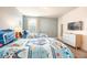 Charming bedroom with twin beds featuring unique Star Wars themed bedding, a TV, and bright natural light at 9036 Stinger E Dr, Davenport, FL 33896