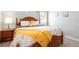 A well-lit bedroom features a wooden bed frame and a charming yellow throw blanket at 9036 Stinger E Dr, Davenport, FL 33896