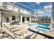 Beautiful backyard with screened-in pool, hot tub, patio and ample seating for outdoor relaxation at 9036 Stinger E Dr, Davenport, FL 33896
