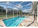 Stunning backyard showcasing a screened-in pool and spa with lounge seating and privacy fence at 9036 Stinger E Dr, Davenport, FL 33896