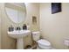 Bathroom featuring a pedestal sink, decorative mirror, and toilet at 9535 Silver Buttonwood St, Orlando, FL 32832