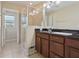 Bathroom featuring a tiled shower with a glass partition and dual granite-topped sinks at 9535 Silver Buttonwood St, Orlando, FL 32832