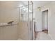 Bright bathroom with a glass shower, safety bar, and an open doorway at 9535 Silver Buttonwood St, Orlando, FL 32832