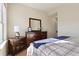 Bedroom featuring a dresser with a mirror, a nightstand, and a bed with a blue throw at 9535 Silver Buttonwood St, Orlando, FL 32832