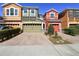 Exterior view of colorful townhomes with brick driveways and attached garages at 9535 Silver Buttonwood St, Orlando, FL 32832