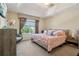 Bright main bedroom featuring a trey ceiling, a large window, and comfortable furnishings at 9535 Silver Buttonwood St, Orlando, FL 32832