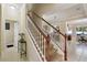 Staircase with wood and white banister, carpeted steps, and a view into the dining room at 9535 Silver Buttonwood St, Orlando, FL 32832