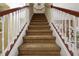 Carpeted staircase with white railings and natural wood trim leading to the upper level at 9535 Silver Buttonwood St, Orlando, FL 32832