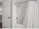 Clean, bright bathroom showcasing a shower-tub combination with white tile and a shower curtain at 1048 Lake Berkley Dr, Kissimmee, FL 34746