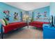 Bright blue bedroom featuring twin beds with Disney-themed decor, and a floor lamp at 1048 Lake Berkley Dr, Kissimmee, FL 34746