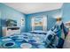 Bright blue bedroom featuring two twin beds with matching bedding and a TV at 1048 Lake Berkley Dr, Kissimmee, FL 34746