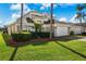 This two-story home includes a well-maintained lawn, a two-car garage, and tropical landscaping at 1048 Lake Berkley Dr, Kissimmee, FL 34746