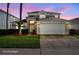 Charming two-story home featuring a manicured lawn, a two-car garage, and a beautifully lit entrance at 1048 Lake Berkley Dr, Kissimmee, FL 34746