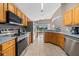 Well-lit kitchen featuring stainless steel appliances, light wood cabinetry, and tile flooring at 1048 Lake Berkley Dr, Kissimmee, FL 34746
