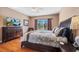Comfortable main bedroom featuring a large bed, wood floors, and a window with a view at 1048 Lake Berkley Dr, Kissimmee, FL 34746