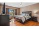 Main bedroom showcasing a large bed, wood floors, and window with a view at 1048 Lake Berkley Dr, Kissimmee, FL 34746