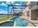 Backyard featuring a screened-in pool, a spa, and views of the serene lake beyond at 1048 Lake Berkley Dr, Kissimmee, FL 34746